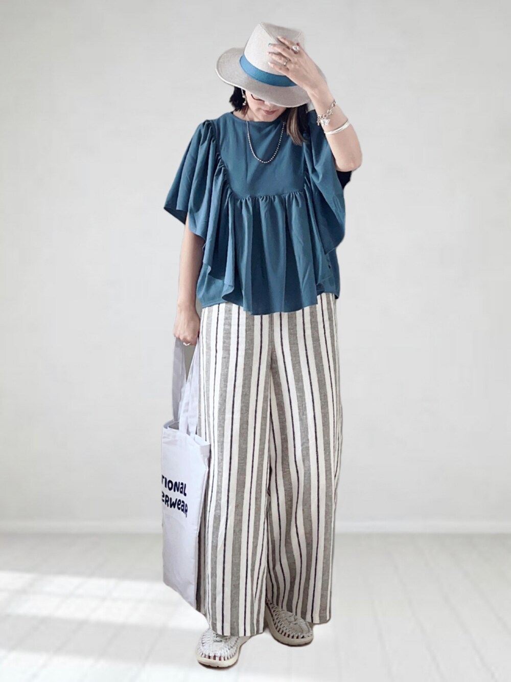 その他のその他パンツ、ブルー系のTシャツ/カットソー、ホワイト系のトートバッグを着用したレディースの春コーディネートの3枚目の写真