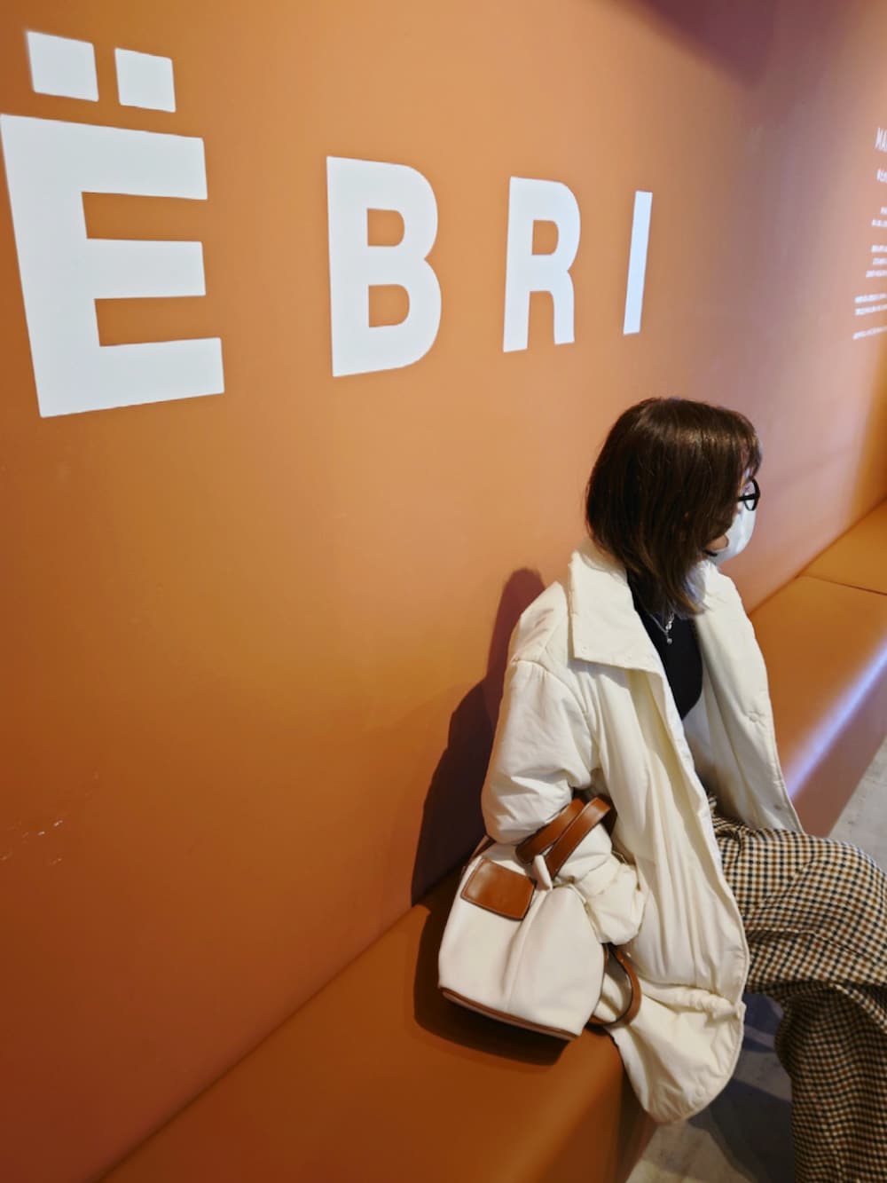 ホワイト系のその他アウター、ブラック系のニット/セーター、ベージュ系のサロペット/オーバーオールを着用したレディースの冬コーディネートの4枚目の写真