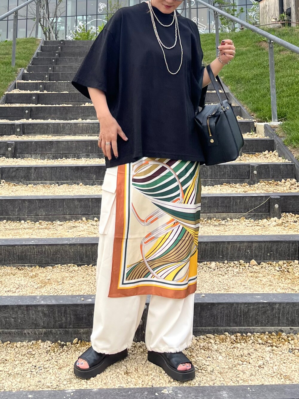 ブラック系のTシャツ/カットソー、ホワイト系のその他パンツ、ブラック系のサンダルを着用したレディースの夏コーディネートの4枚目の写真