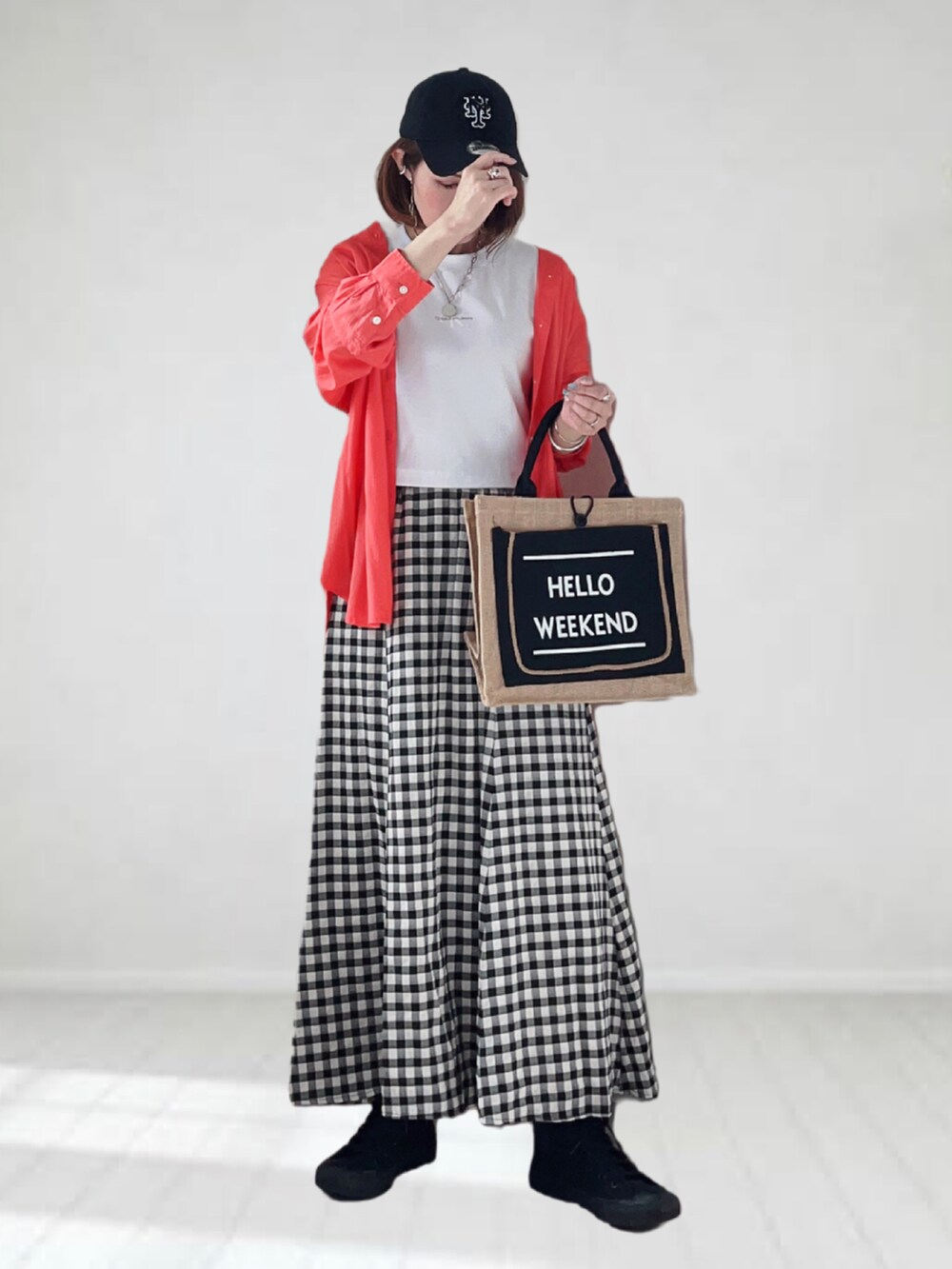 ホワイト系のTシャツ/カットソー、オレンジ系のシャツ/ブラウス、ブラック系のスカートを着用したレディースの春コーディネートの2枚目の写真