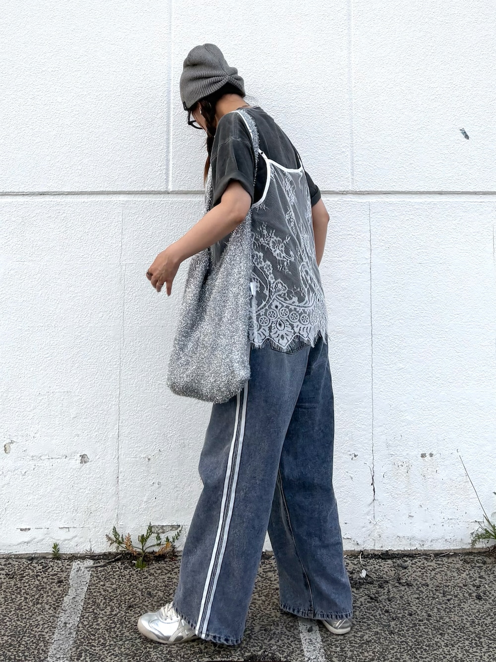 ブルー系のデニムパンツ、シルバー系のトートバッグ、シルバー系のスニーカーを着用したレディースの夏コーディネートの5枚目の写真