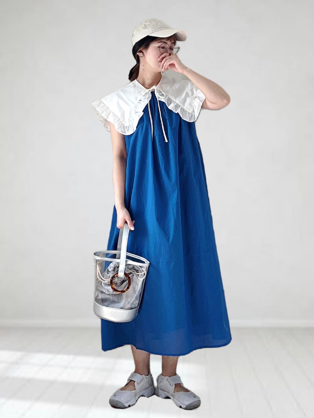 ブルー系のワンピース、ホワイト系のシャツ/ブラウス、シルバー系のショルダーバッグを着用したレディースの春コーディネートの2枚目の写真