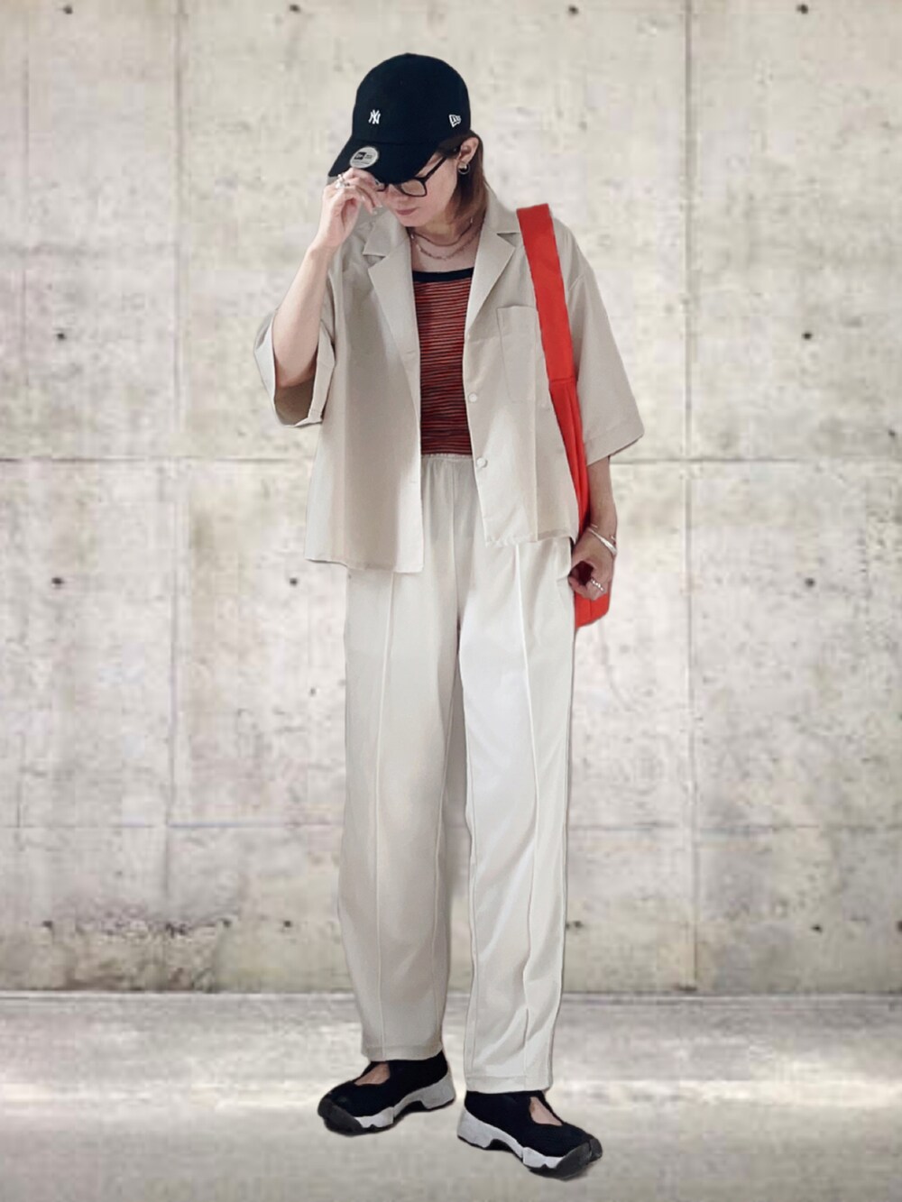 ホワイト系のシャツ/ブラウス、ホワイト系のパンツ、オレンジ系のトートバッグを着用したレディースの夏コーディネートの2枚目の写真