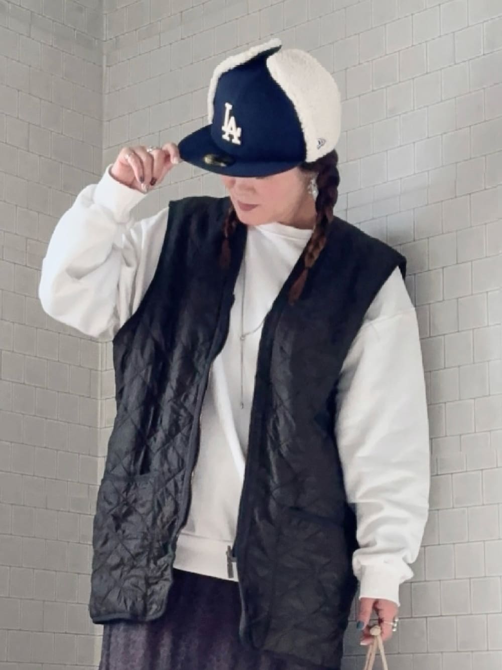 その他のスカート、ブラウン系のブーツ、グリーン系のベストを着用したレディースの冬コーディネートの5枚目の写真