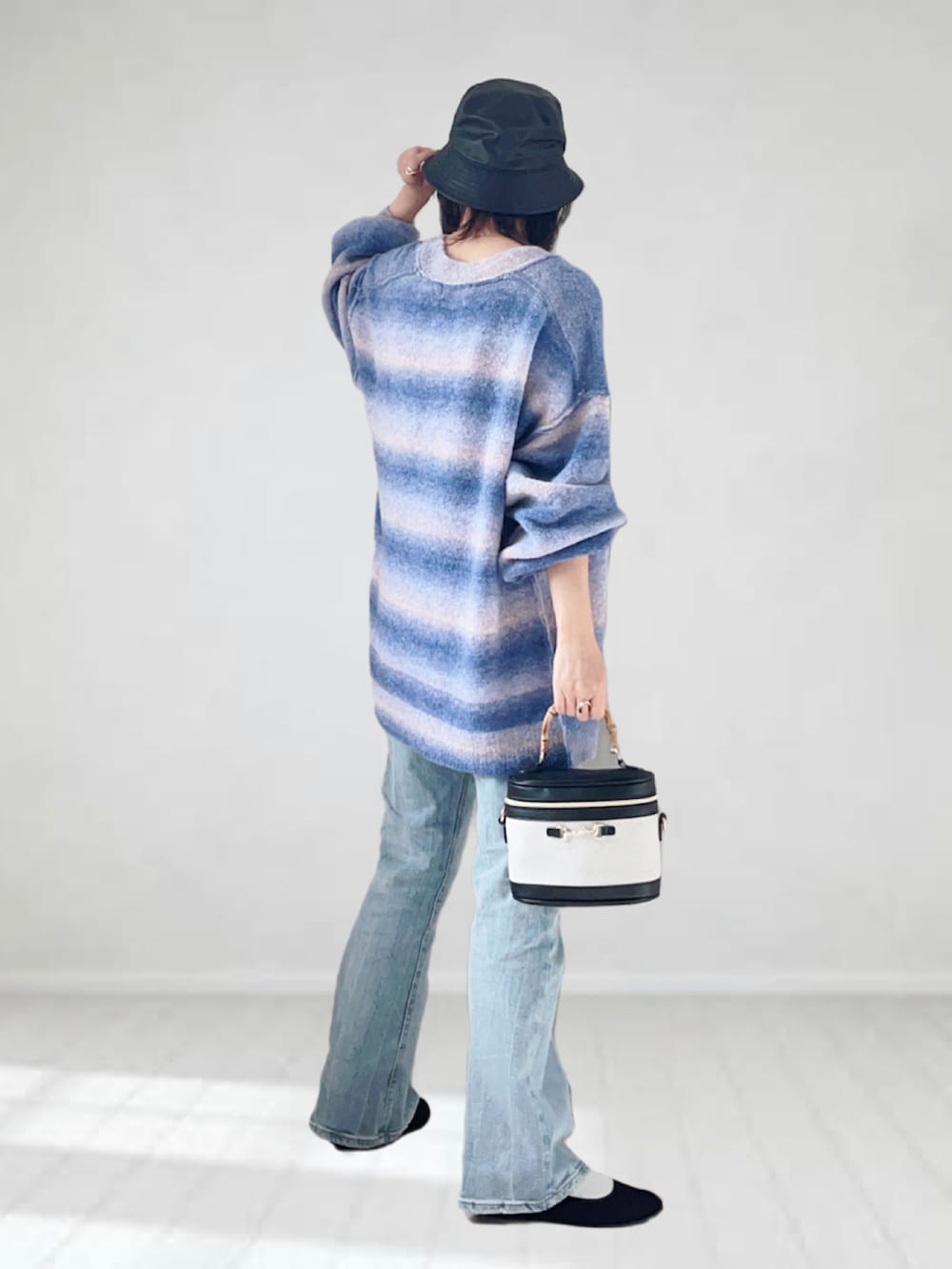 ブルー系のカーディガン/ボレロ、ブルー系のデニムパンツ、ブラック系のタンクトップを着用したレディースの秋コーディネートの2枚目の写真