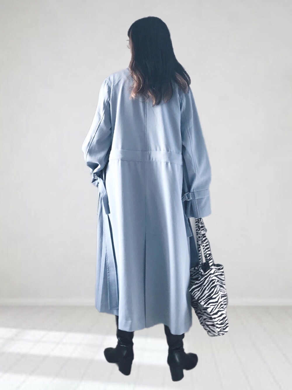 ブルー系のトレンチコート、ホワイト系のTシャツ/カットソー、ホワイト系のTシャツ/カットソーを着用したレディースの冬コーディネートの3枚目の写真