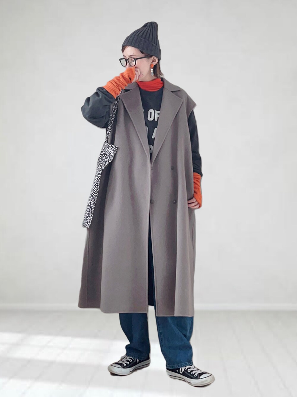 ブラウン系のチェスターコート、オレンジ系のTシャツ/カットソー、グレー系のスウェットを着用したレディースの冬コーディネートの2枚目の写真