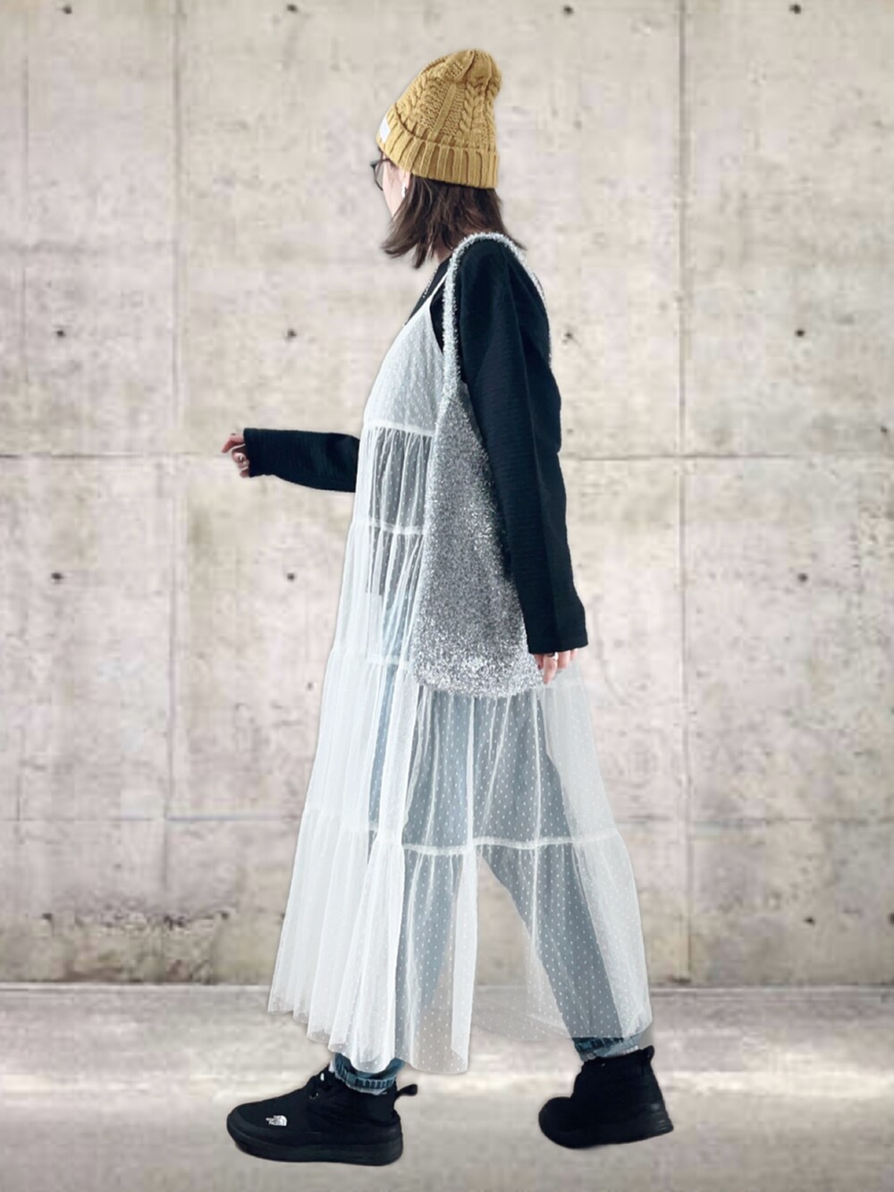 ブラック系のTシャツ/カットソー、ホワイト系のワンピース/ドレス、ブルー系のデニムパンツを着用したレディースの冬コーディネートの3枚目の写真