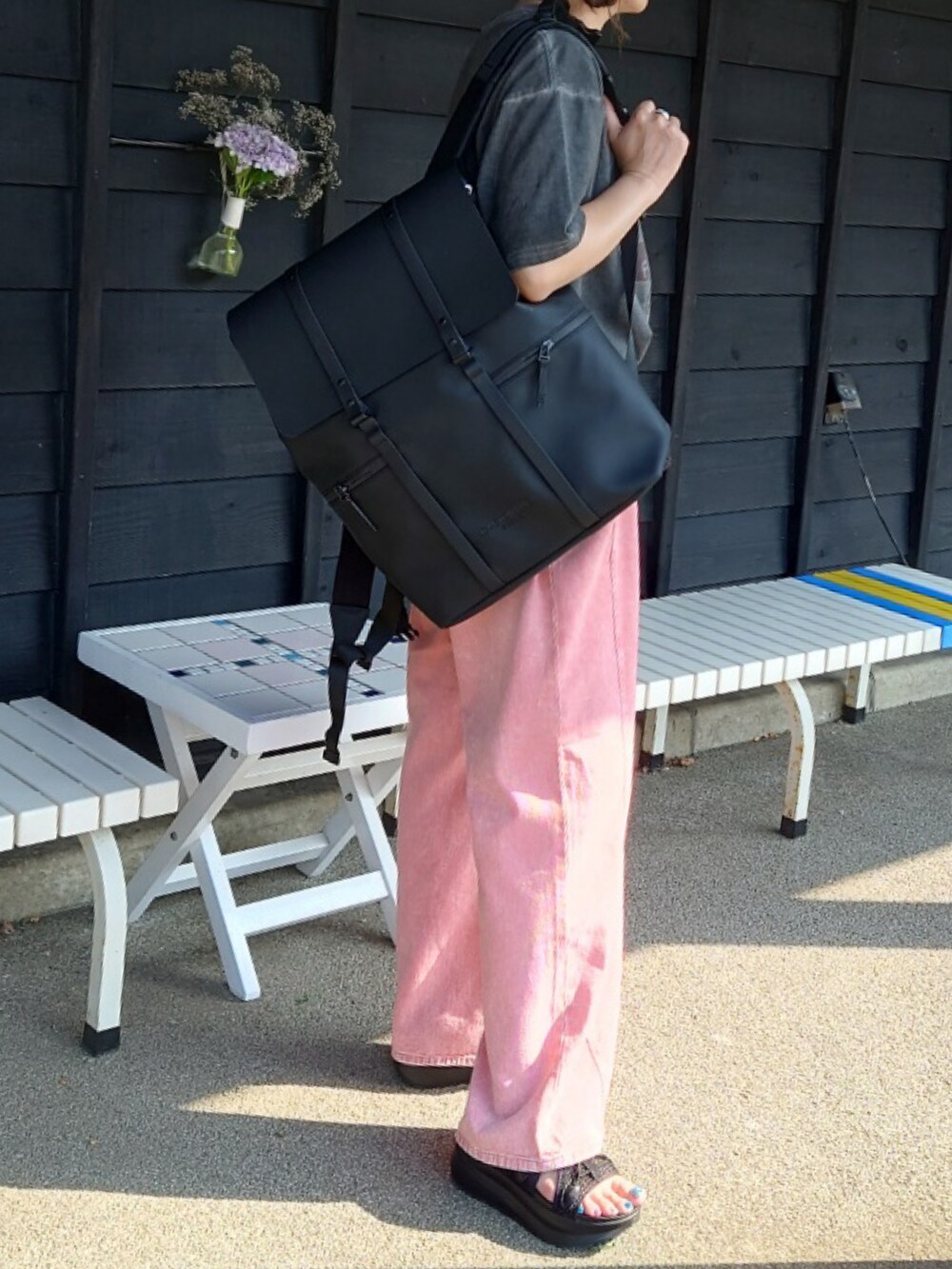 ブラック系のバックパック/リュック、グレー系のTシャツ/カットソー、ブラック系のサンダルを着用したレディースの夏コーディネートの5枚目の写真