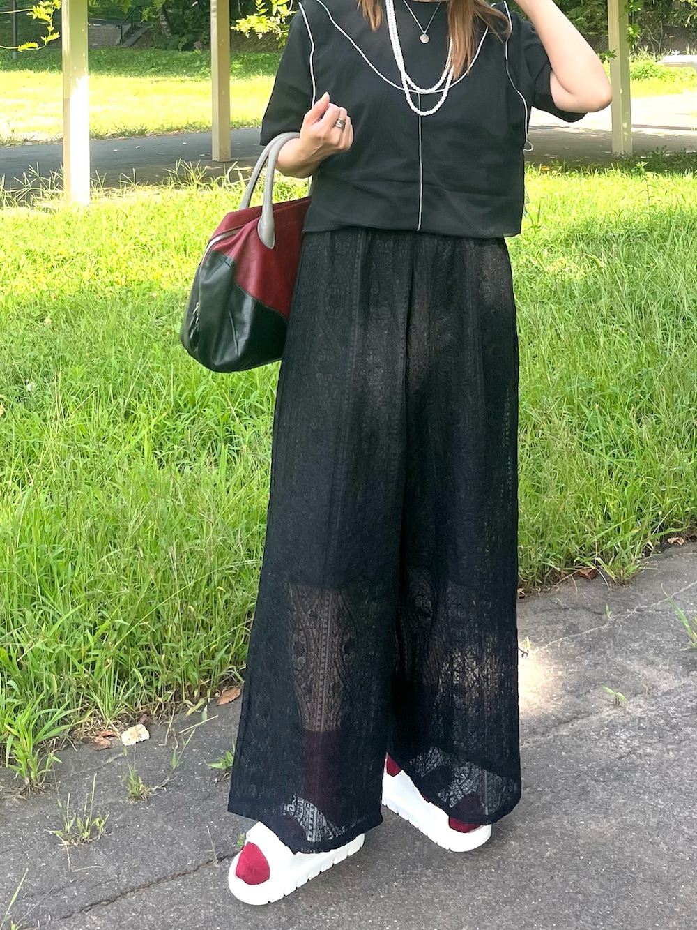 ブラック系のその他パンツ、ブラック系のTシャツ/カットソー、レッド系のトートバッグを着用したレディースの夏コーディネートの3枚目の写真