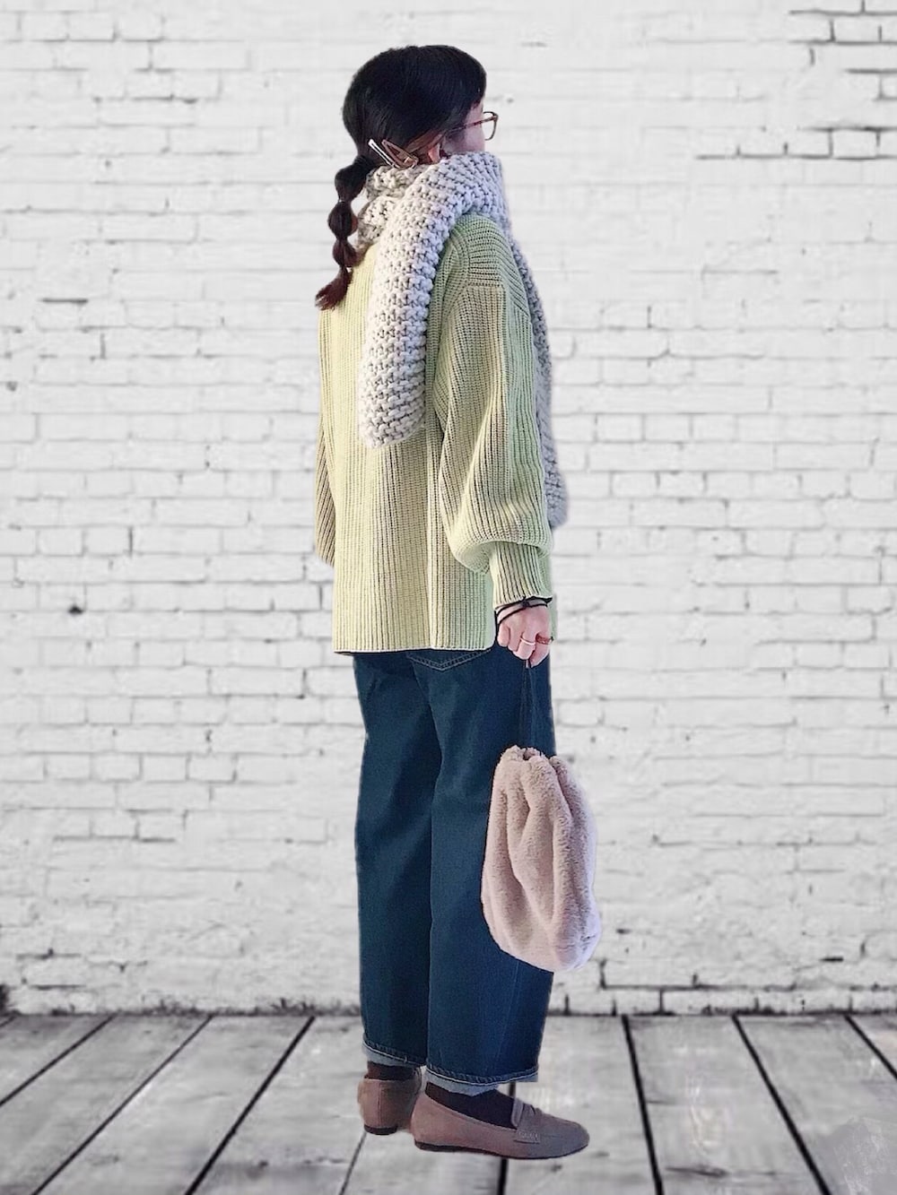 イエロー系のカーディガン/ボレロ、ブルー系のデニムパンツ、ブラック系のショルダーバッグを着用したレディースの秋コーディネートの2枚目の写真