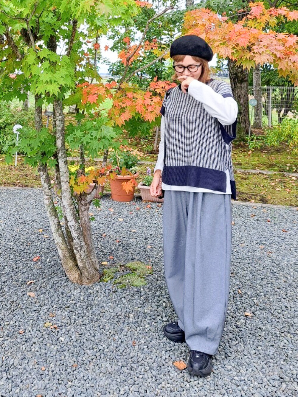 ブルー系のニット/セーター、グレー系のその他パンツ、ブラック系のスニーカーを着用したレディースの秋コーディネートの5枚目の写真