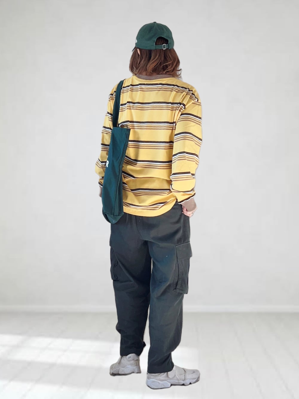 イエロー系のTシャツ/カットソー、グレー系のカーゴパンツ、グリーン系のトートバッグを着用したレディースの春コーディネートの4枚目の写真