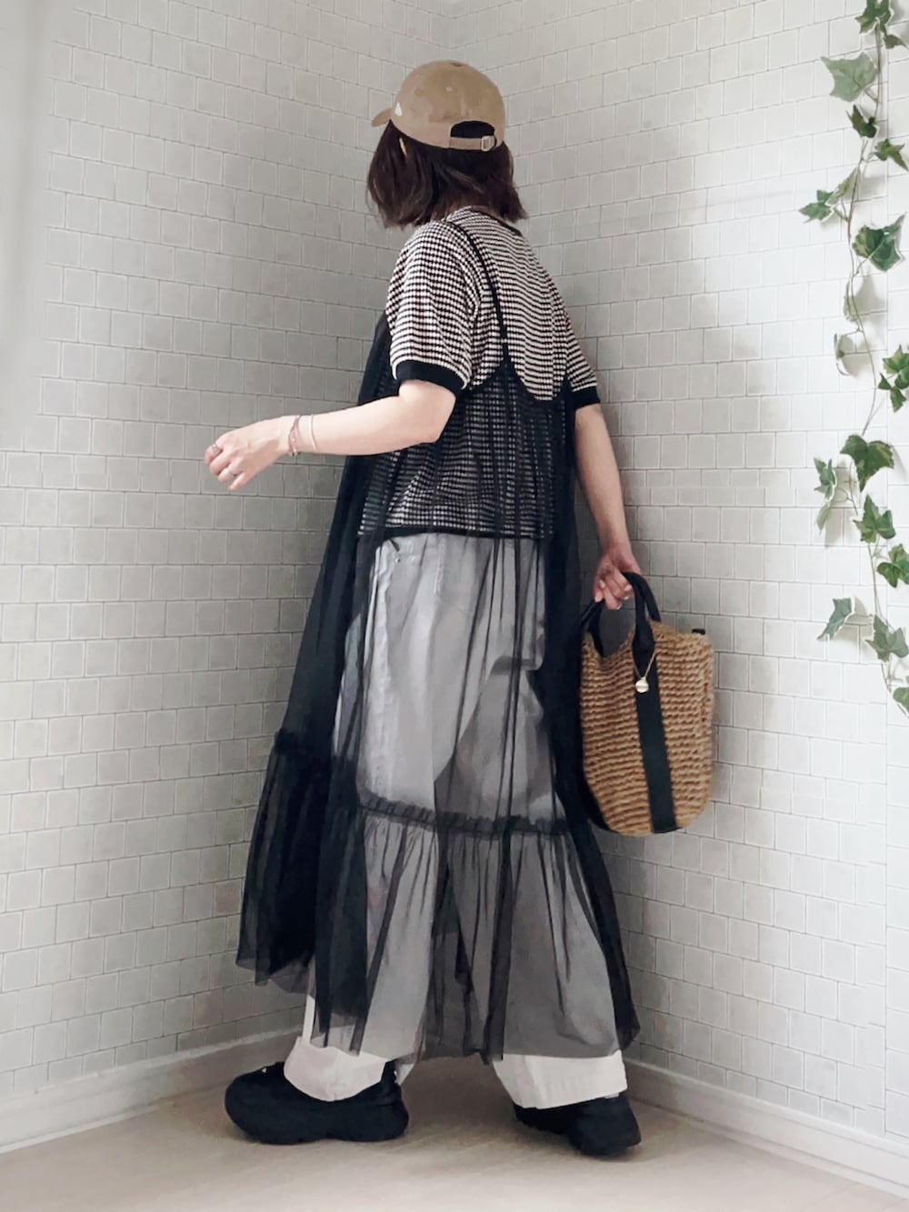 ブラック系のTシャツ/カットソー、ブラック系のショルダーバッグ、グレー系のパンツを着用したレディースの春コーディネートの3枚目の写真