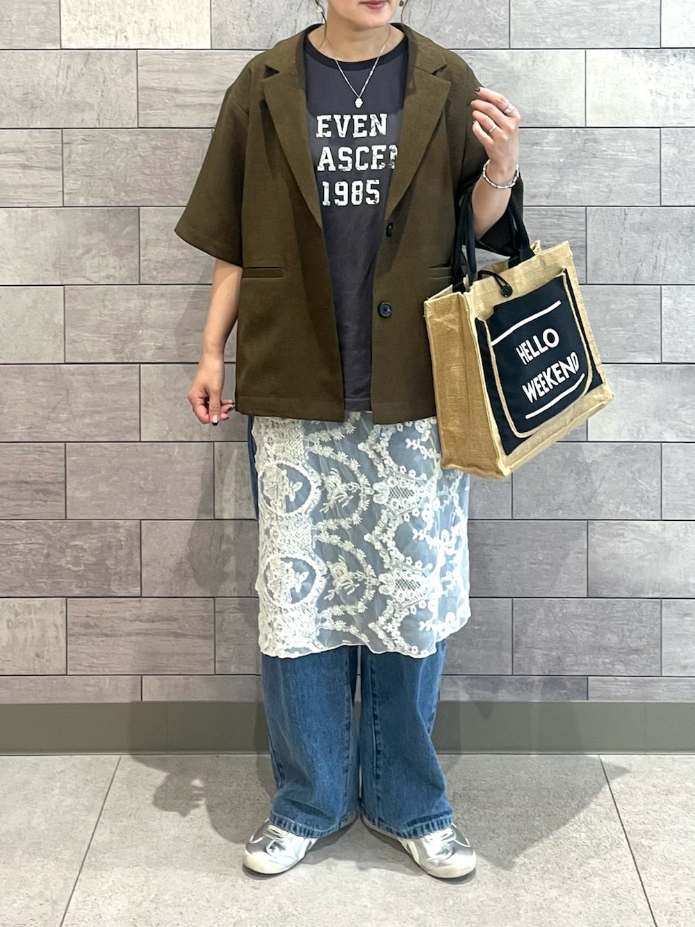 ブラウン系のテーラードジャケット、グレー系のTシャツ/カットソー、ブルー系のデニムパンツを着用したレディースの夏コーディネートの2枚目の写真