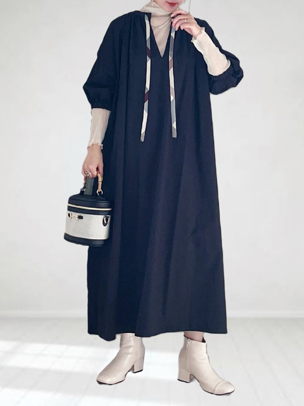 ブラック系のワンピース、ホワイト系のTシャツ/カットソー、ホワイト系のハンドバッグを着用したレディースの秋コーディネートの3枚目の写真