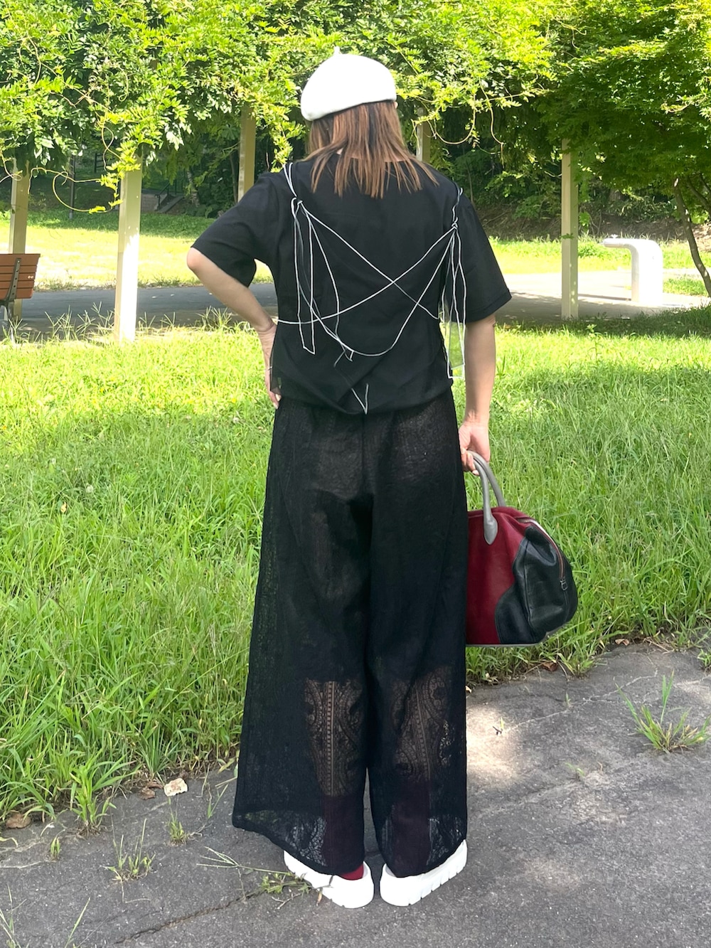 ブラック系のその他パンツ、ブラック系のTシャツ/カットソー、レッド系のトートバッグを着用したレディースの夏コーディネートの4枚目の写真