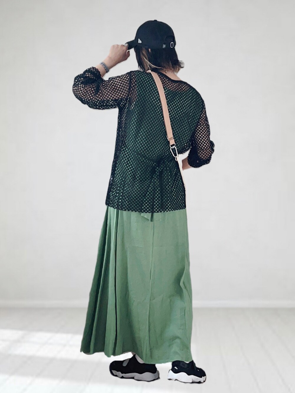 グリーン系のワンピース、ブラック系のTシャツ/カットソー、ベージュ系のトートバッグを着用したレディースの夏コーディネートの2枚目の写真