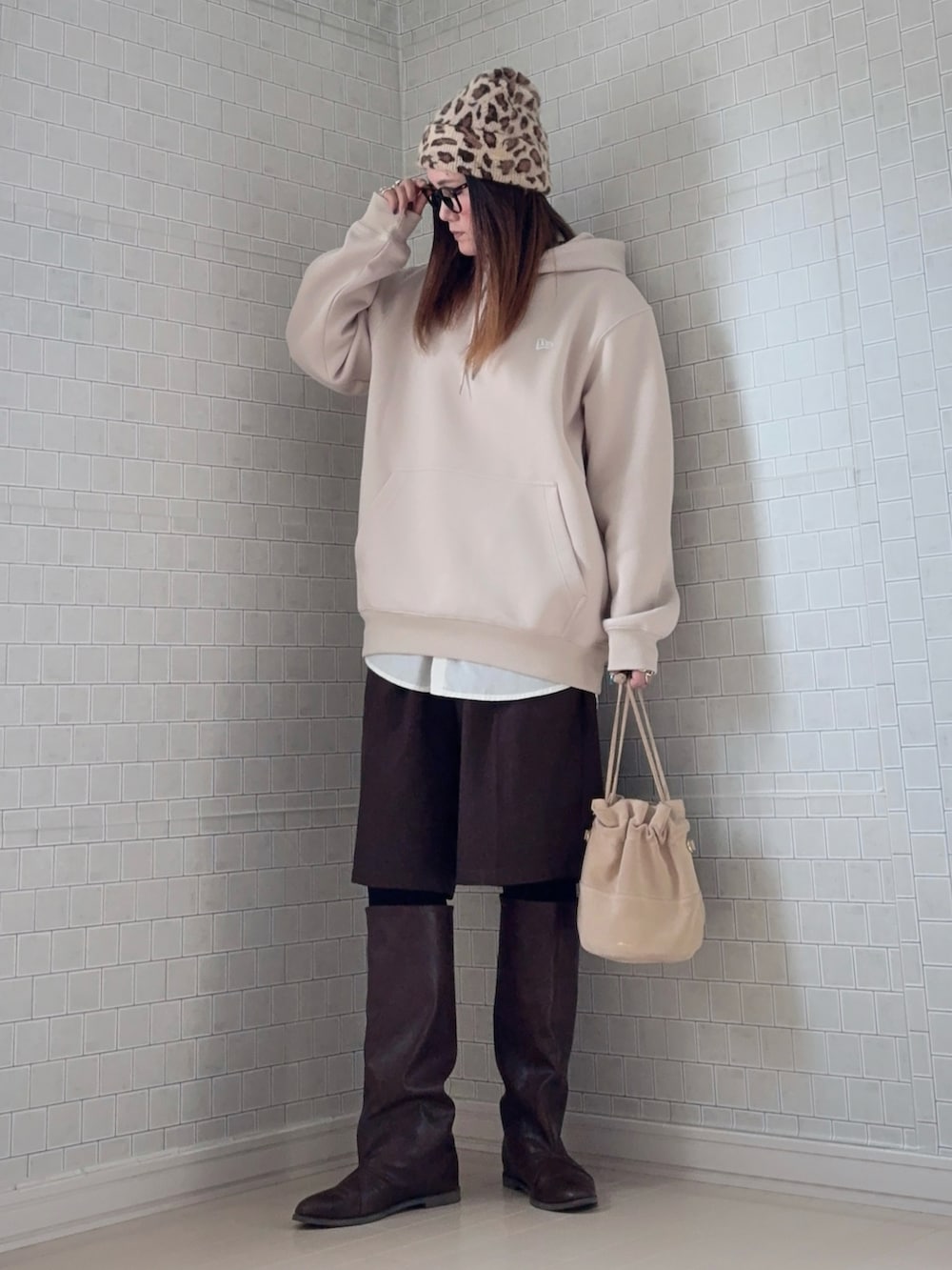 ベージュ系のパーカー、ブラウン系のその他パンツ、ブラウン系のブーツを着用したレディースの冬コーディネートの2枚目の写真