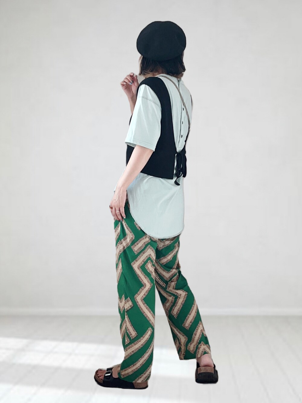 グリーン系のその他パンツ、グリーン系のTシャツ/カットソー、ブラック系のベストを着用したレディースの夏コーディネートの2枚目の写真
