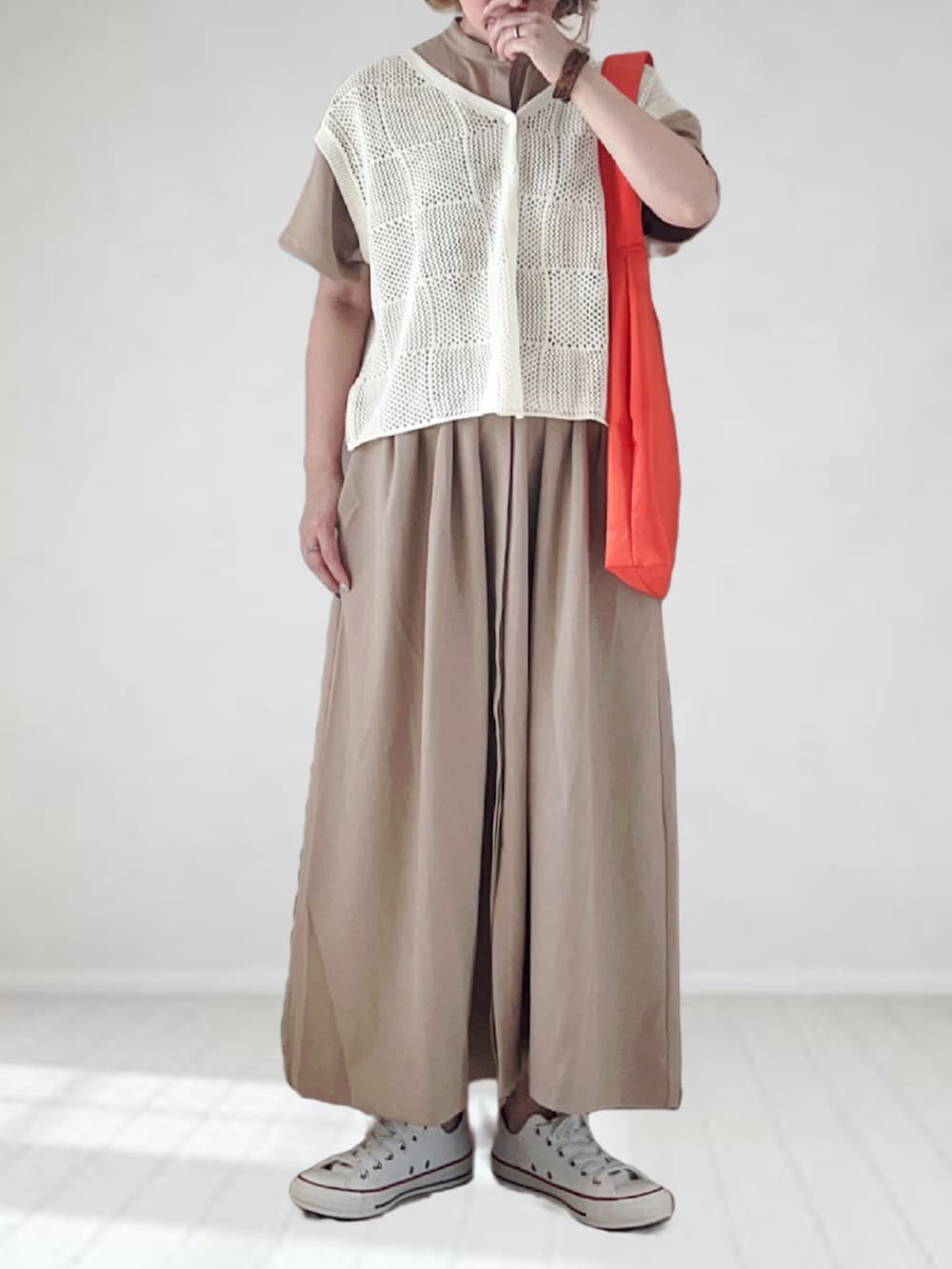 ベージュ系のワンピース、ホワイト系のニット/セーター、オレンジ系のトートバッグを着用したレディースの夏コーディネートの3枚目の写真