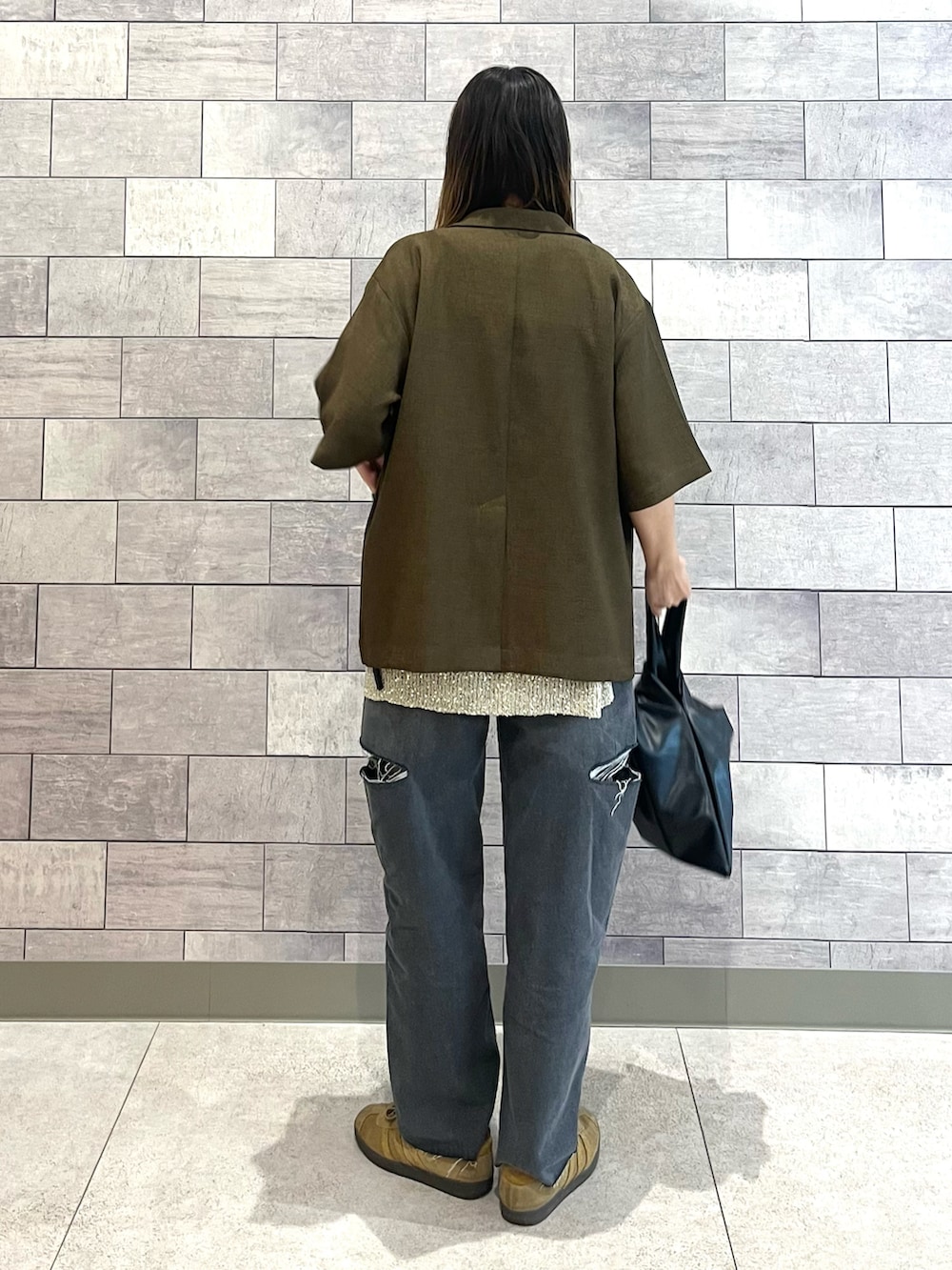 ブラック系のデニムパンツ、ブラウン系のテーラードジャケット、ゴールド系のベストを着用したレディースの夏コーディネートの5枚目の写真