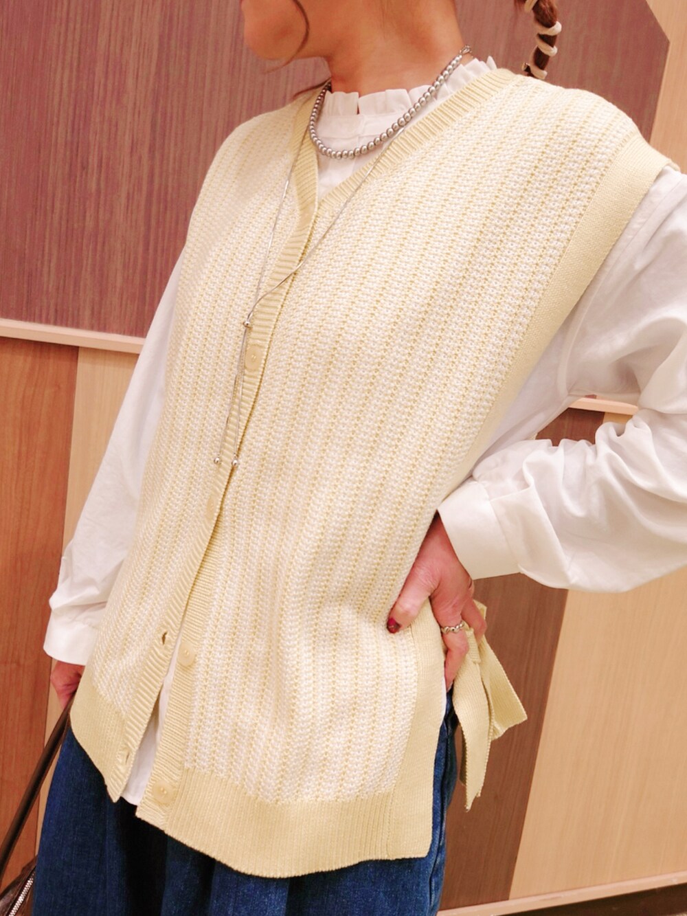 グリーン系のベスト、ブルー系のデニムパンツ、ホワイト系のシャツ/ブラウスを着用したレディースの冬コーディネートの3枚目の写真