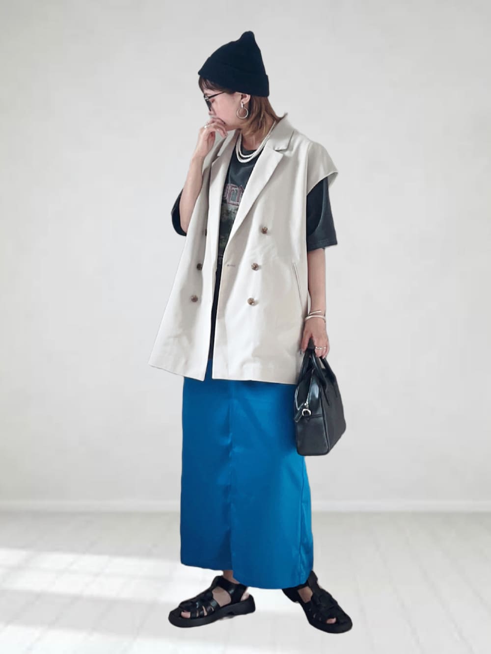 ブラック系のTシャツ/カットソー、ホワイト系のベスト、ブルー系のスカートを着用したレディースの夏コーディネートの2枚目の写真