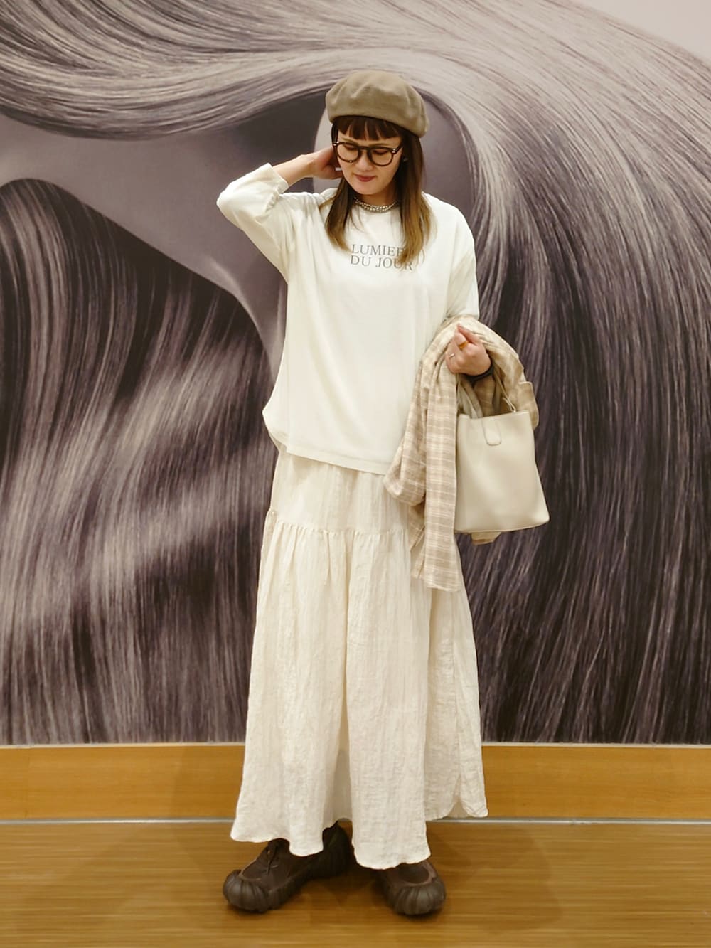 ホワイト系のアンサンブル、ブラウン系のスニーカー、ベージュ系のテーラードジャケットを着用したレディースの春コーディネートの2枚目の写真