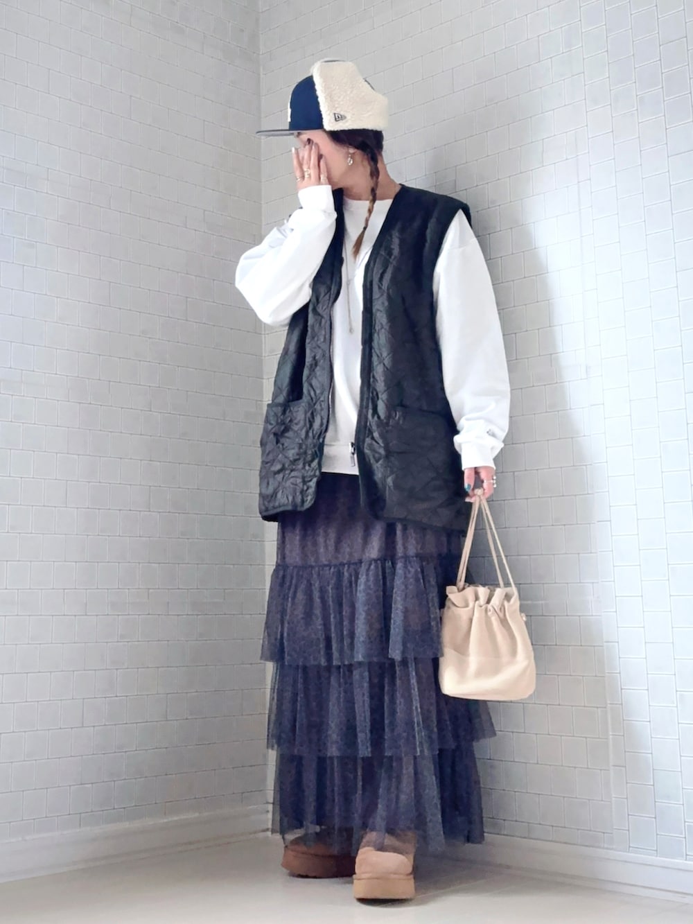 その他のスカート、ブラウン系のブーツ、グリーン系のベストを着用したレディースの冬コーディネートの3枚目の写真