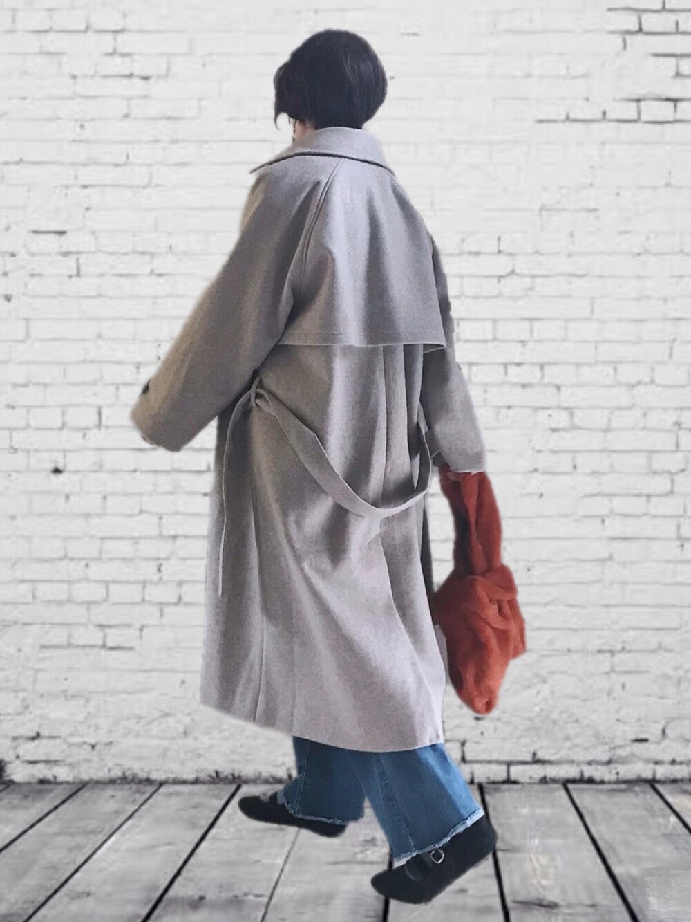 ベージュ系のステンカラーコート、ホワイト系のTシャツ/カットソー、グレー系のワンピースを着用したレディースの秋コーディネートの2枚目の写真