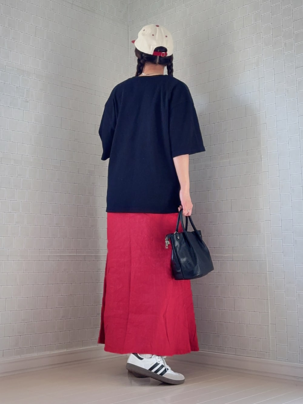 ブラック系のTシャツ/カットソー、ホワイト系のスニーカー、レッド系のキャップを着用したレディースの春コーディネートの3枚目の写真