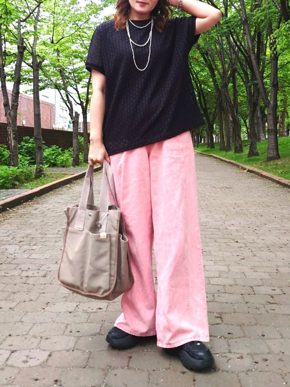 ブラック系のTシャツ/カットソー、ベージュ系のトートバッグ、ピンク系のデニムパンツを着用したレディースの夏コーディネートの2枚目の写真