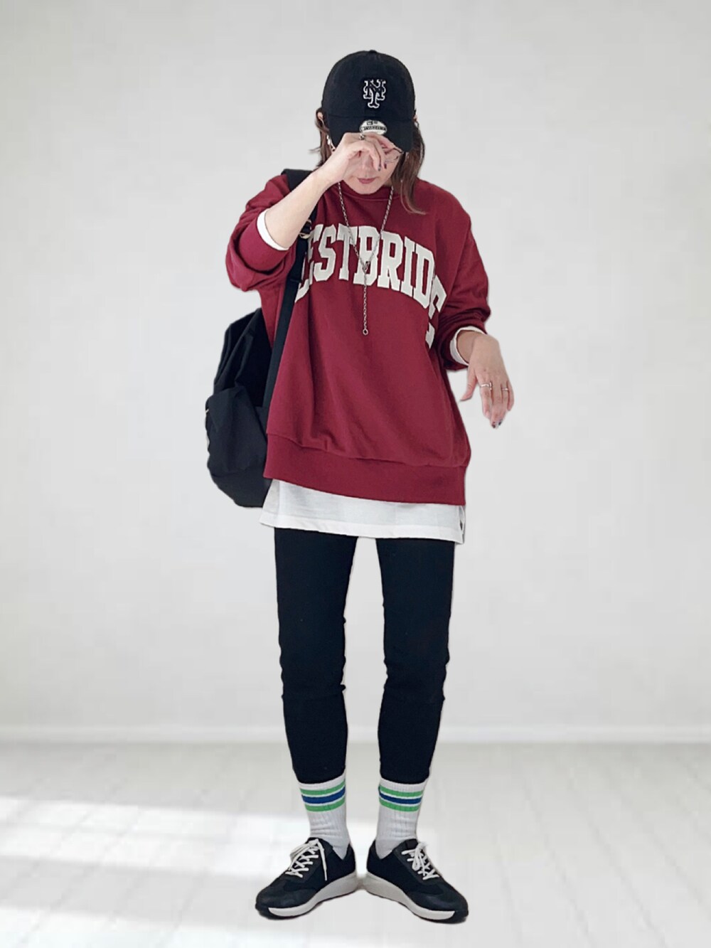 レッド系のTシャツ/カットソー、ホワイト系のTシャツ/カットソー、ブラック系のデニムパンツを着用したレディースの秋コーディネートの2枚目の写真