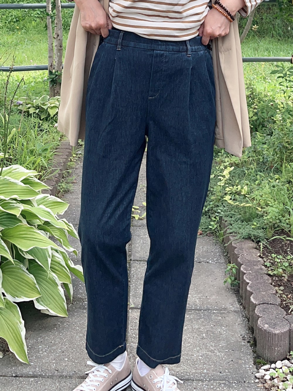 ブルー系のその他パンツ、ベージュ系のスニーカー、ベージュ系のベストを着用したレディースの秋コーディネートの4枚目の写真