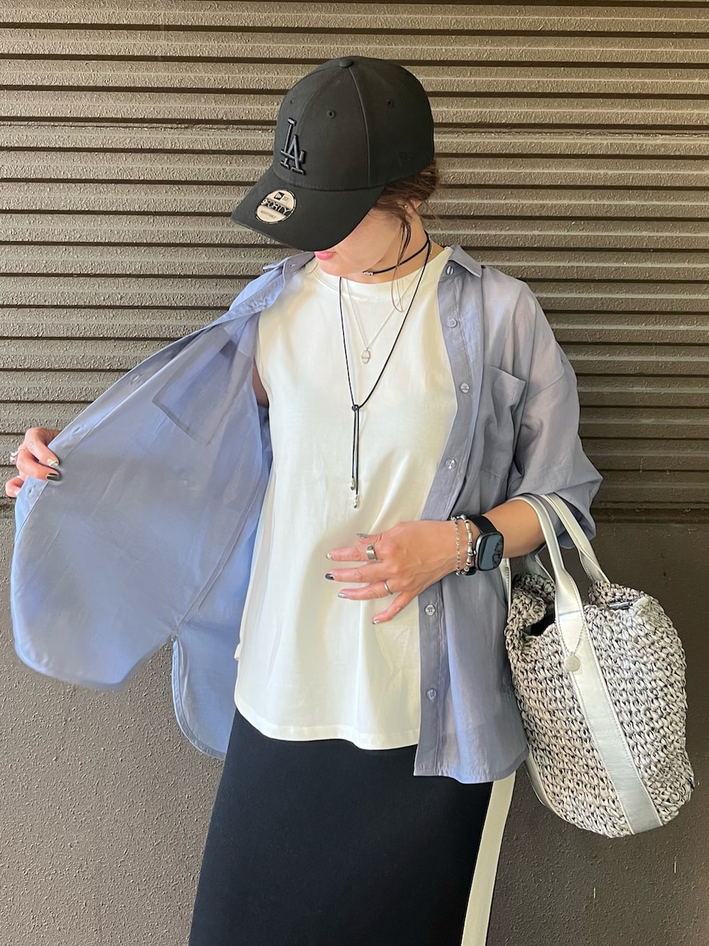 ブラック系のスカート、グレー系のショルダーバッグ、ブラック系のサンダルを着用したレディースの夏コーディネートの4枚目の写真