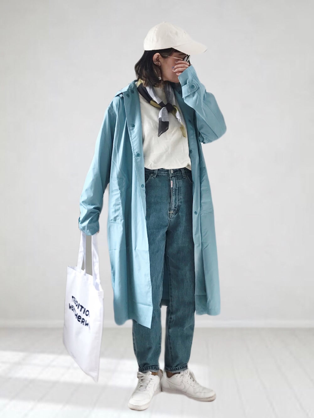 ホワイト系のニット/セーター、ブルー系のデニムパンツ、ホワイト系のトートバッグを着用したレディースの春コーディネートの2枚目の写真