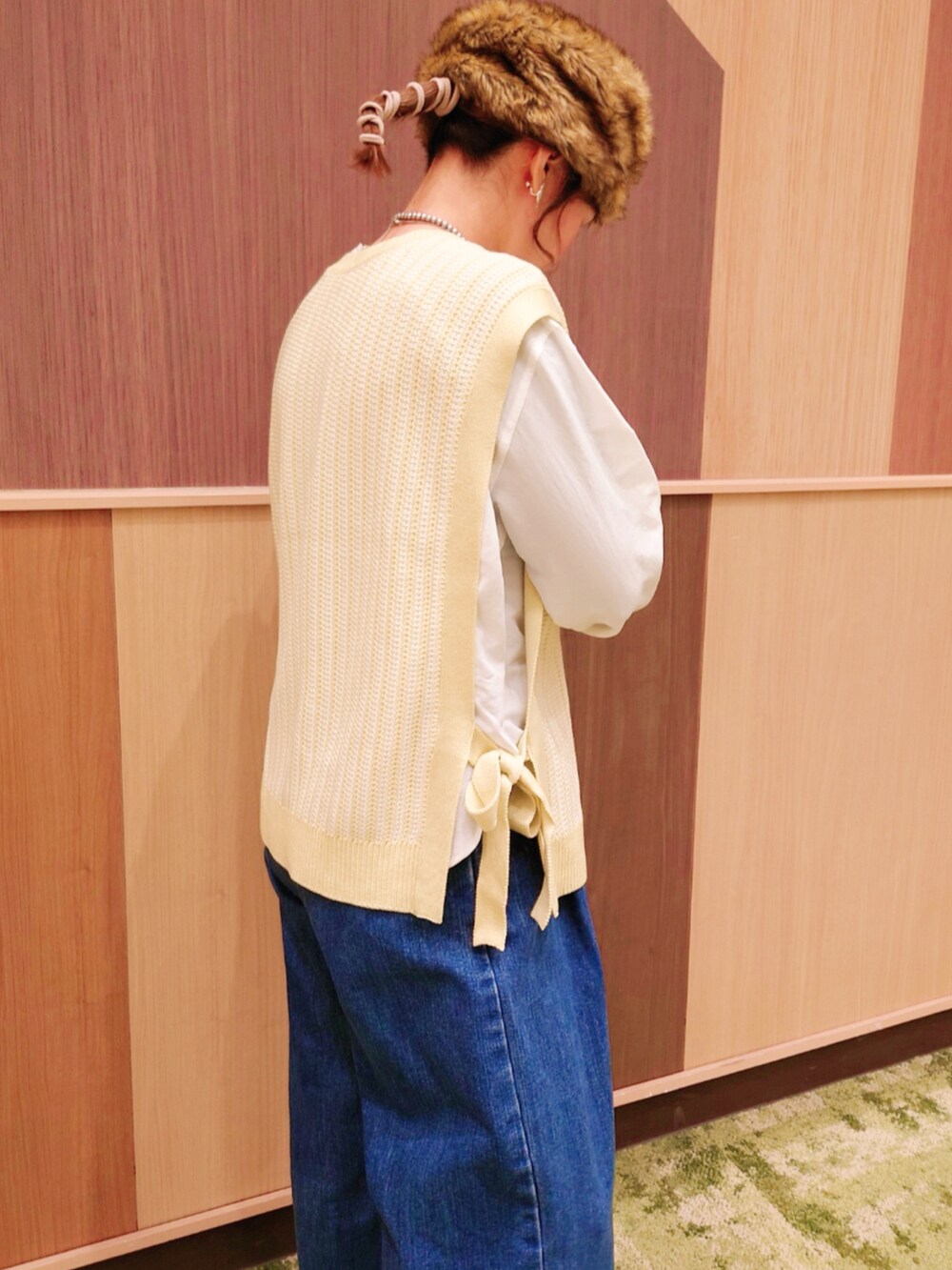 グリーン系のベスト、ブルー系のデニムパンツ、ホワイト系のシャツ/ブラウスを着用したレディースの冬コーディネートの4枚目の写真