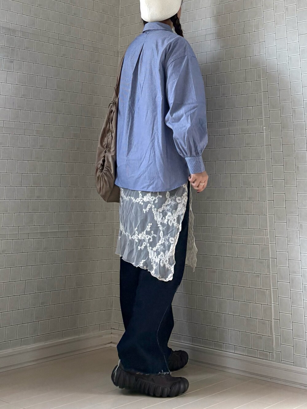 ブルー系のシャツ/ブラウス、ベージュ系のトートバッグ、ブルー系のデニムパンツを着用したレディースの春コーディネートの5枚目の写真