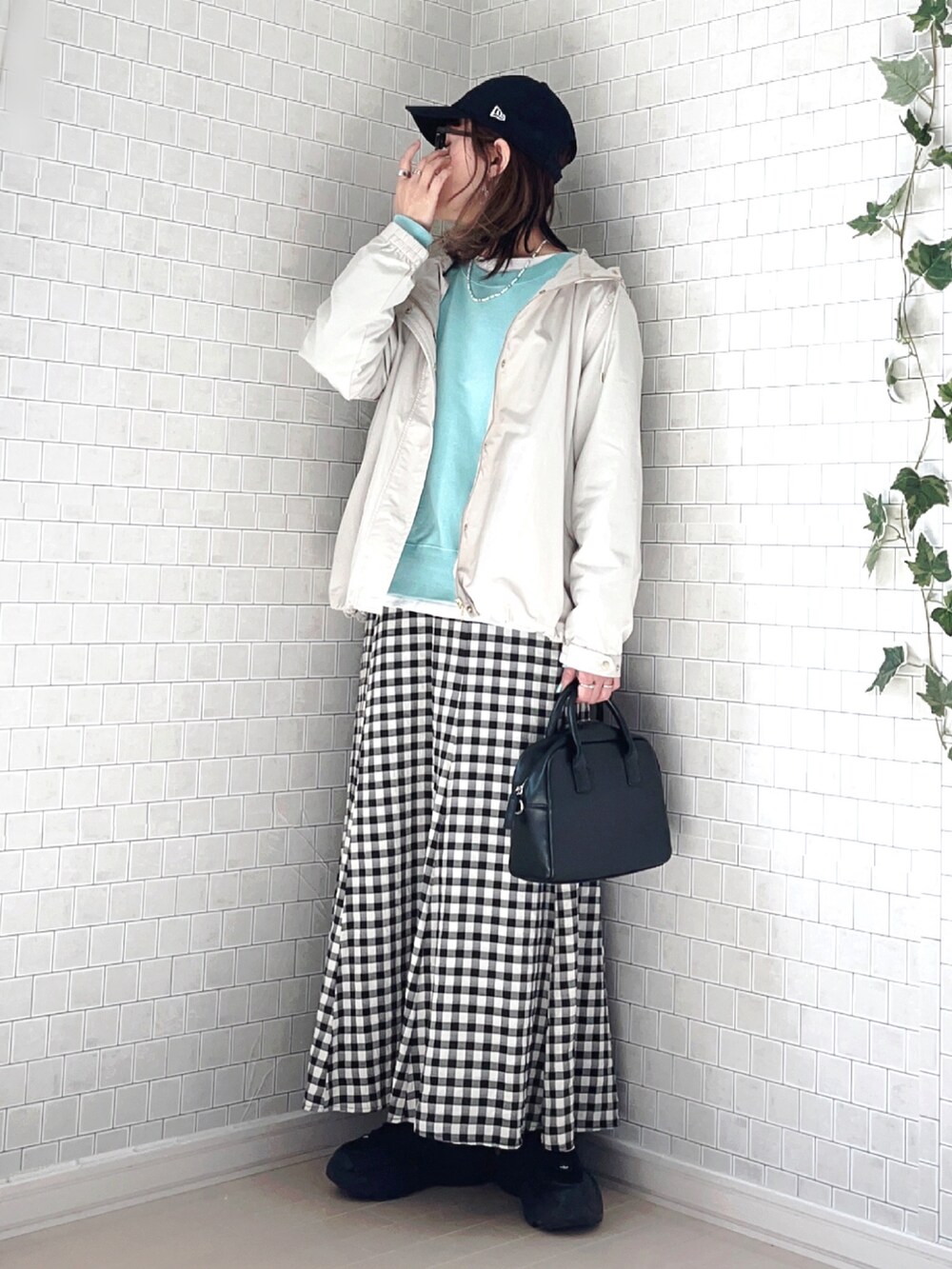 ホワイト系のマウンテンパーカー、ブルー系のTシャツ/カットソー、ブラック系のスカートを着用したレディースの春コーディネートの5枚目の写真