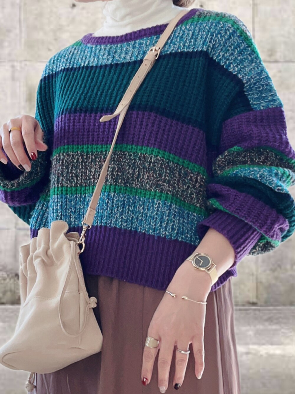 パープル系のニット/セーター、ホワイト系のTシャツ/カットソー、ブラウン系のスカートを着用したレディースの冬コーディネートの2枚目の写真