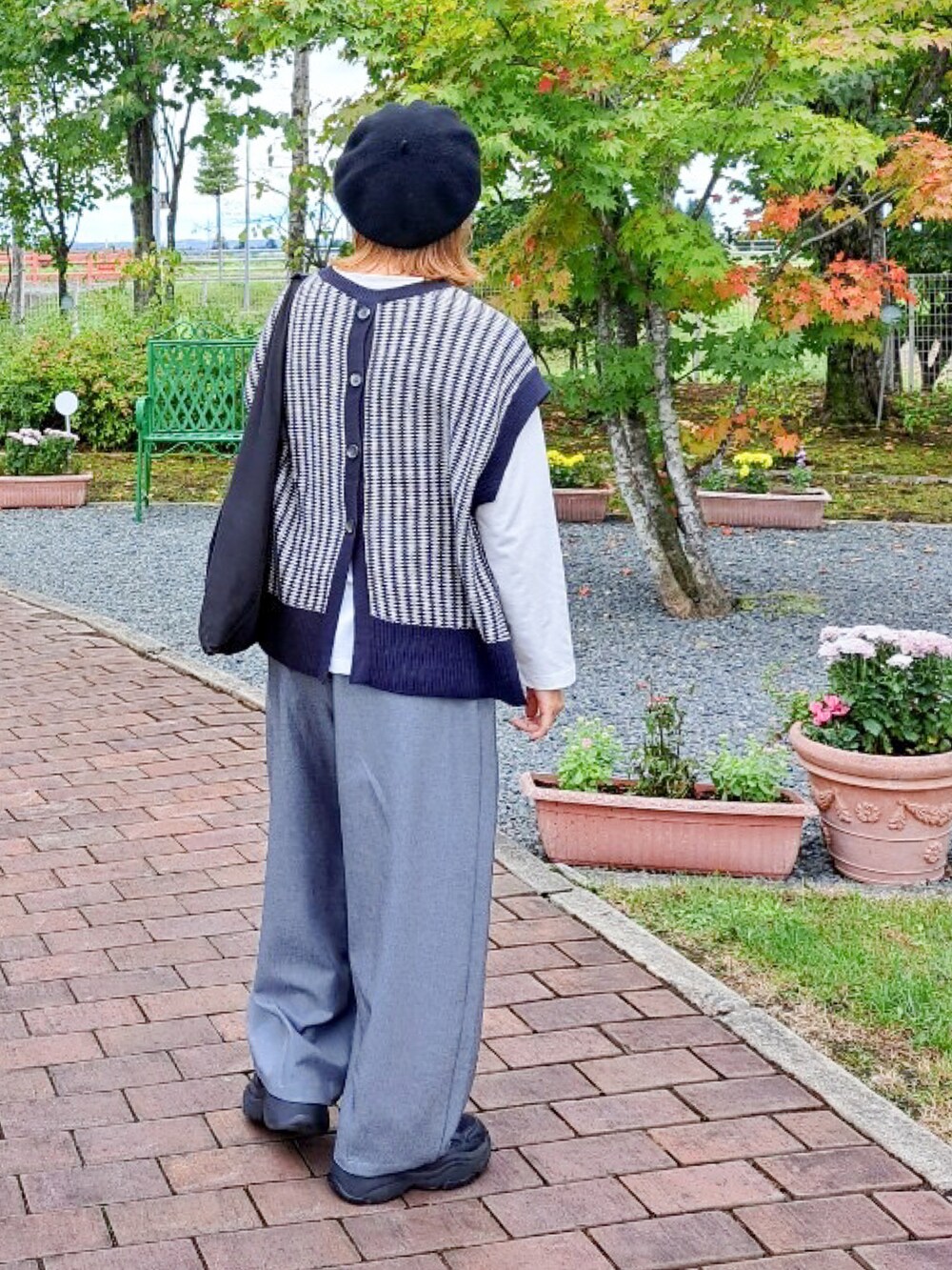 ブルー系のニット/セーター、グレー系のその他パンツ、ブラック系のスニーカーを着用したレディースの秋コーディネートの2枚目の写真