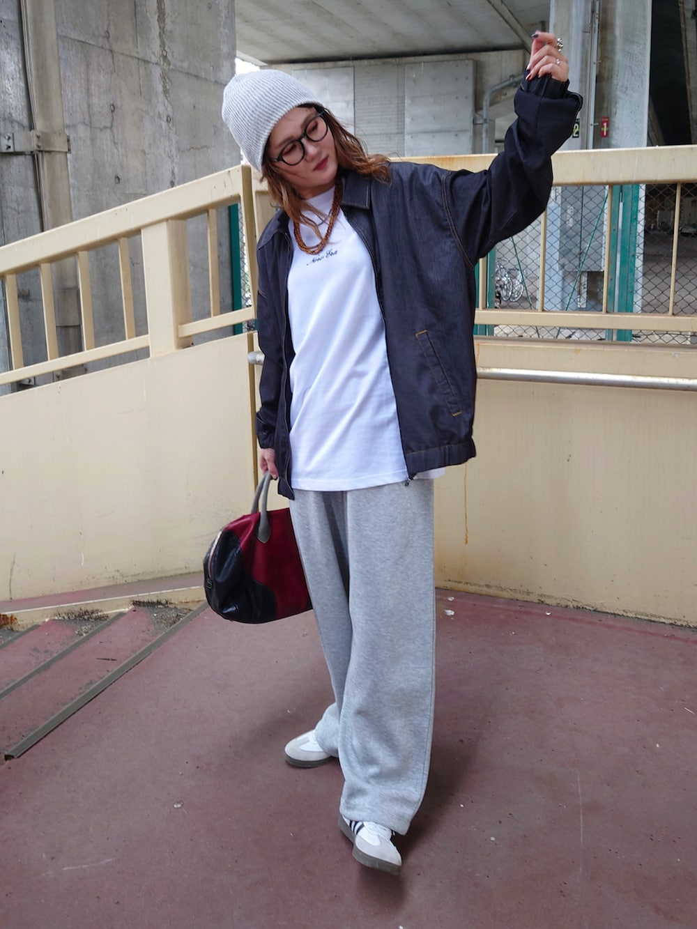 ブラック系のブルゾン、ホワイト系のTシャツ/カットソー、ホワイト系のスニーカーを着用したレディースの夏コーディネートの2枚目の写真