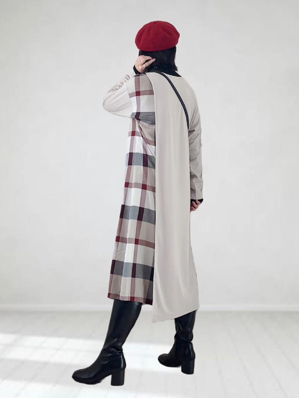 ベージュ系のワンピース、ブラック系のショルダーバッグ、ブラック系のブーツを着用したレディースの秋コーディネートの3枚目の写真