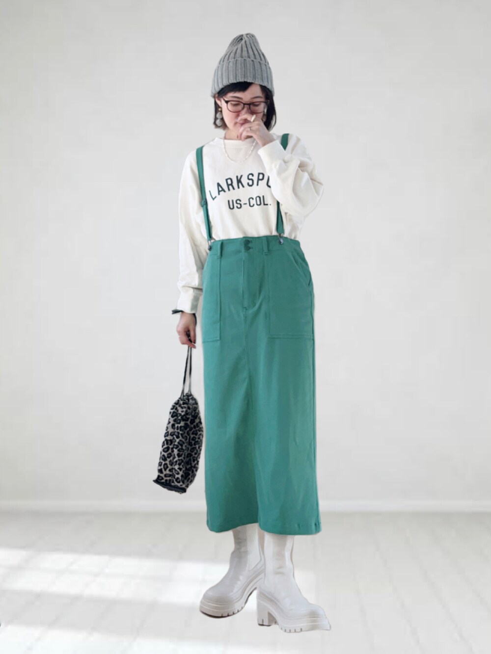 ホワイト系のブーツ、ホワイト系のスウェット、グリーン系のスカートを着用したレディースの秋コーディネートの2枚目の写真