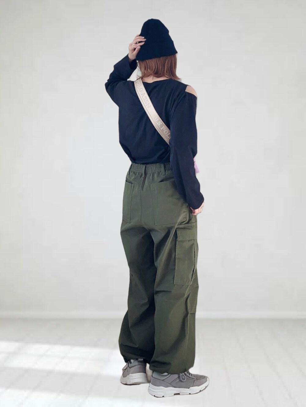 グリーン系のカーゴパンツ、ブラック系のTシャツ/カットソー、パープル系のショルダーバッグを着用したレディースの春コーディネートの3枚目の写真