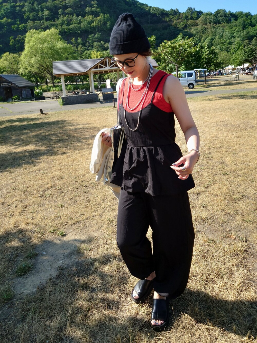 ブラック系のサロペット/オーバーオール、ホワイト系のテーラードジャケット、レッド系のTシャツ/カットソーを着用したレディースの夏コーディネートの2枚目の写真