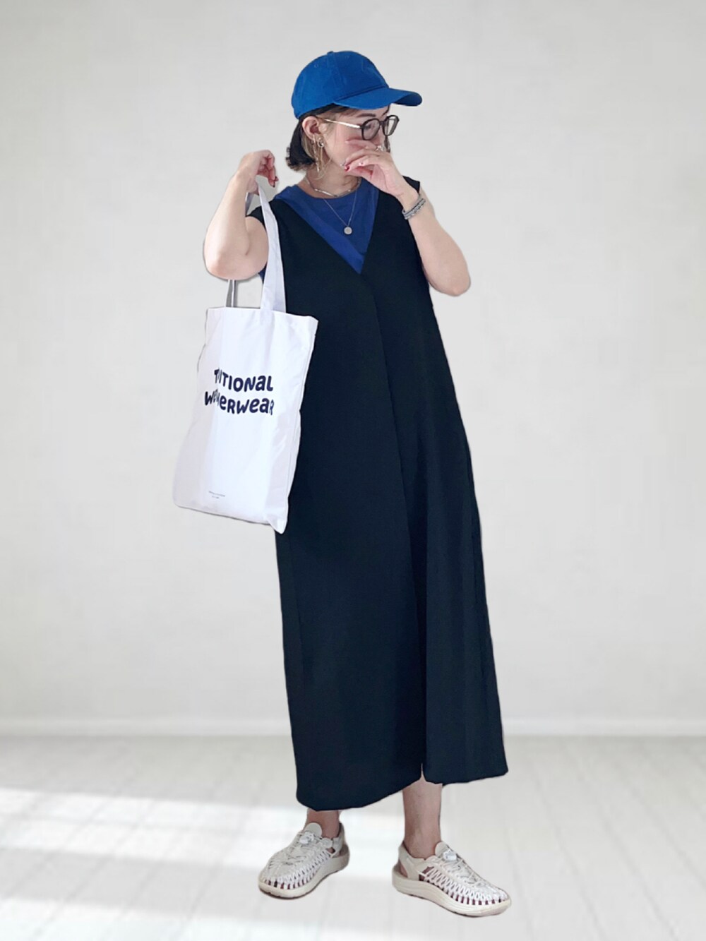 ブラック系のワンピース、ブルー系のTシャツ/カットソー、ホワイト系のトートバッグを着用したレディースの夏コーディネートの2枚目の写真