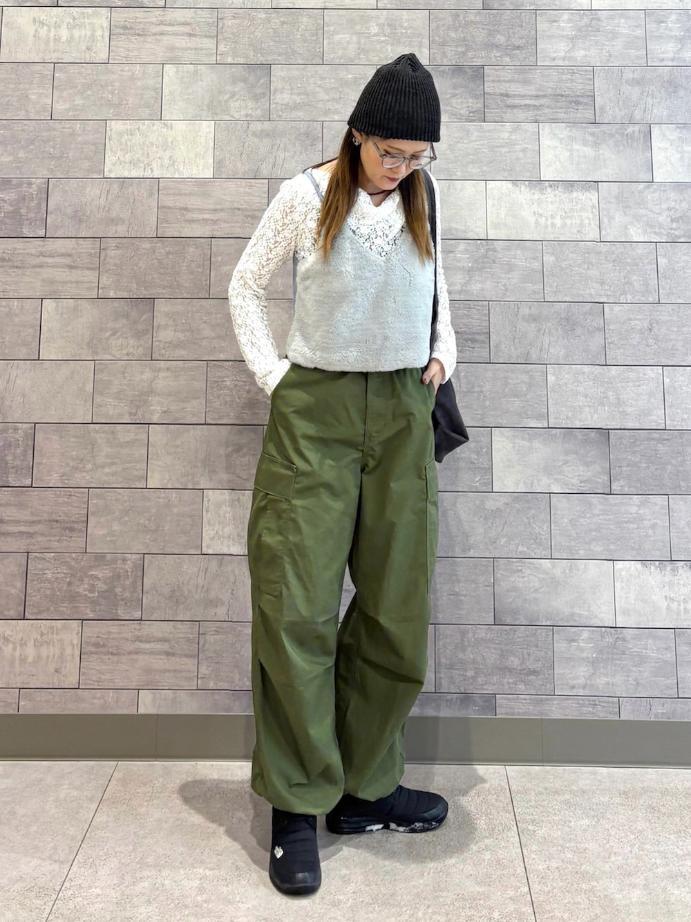 グレー系のトートバッグ、ホワイト系のTシャツ/カットソー、グリーン系のカーゴパンツを着用したレディースの冬コーディネートの2枚目の写真