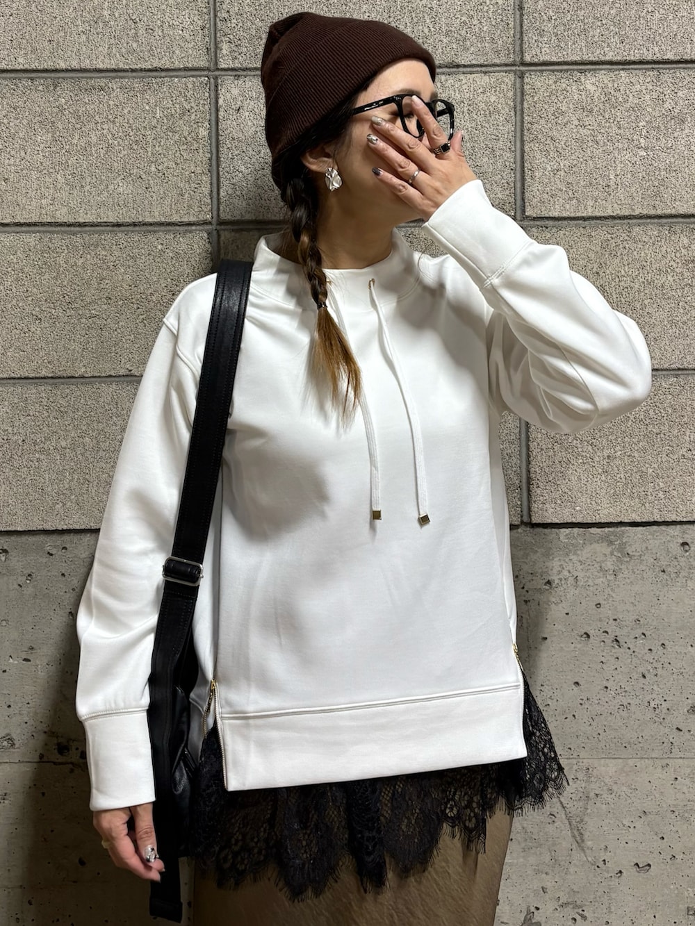 ホワイト系のスウェット、ブラウン系のスニーカー、ブラック系のショルダーバッグを着用したレディースの春コーディネートの4枚目の写真